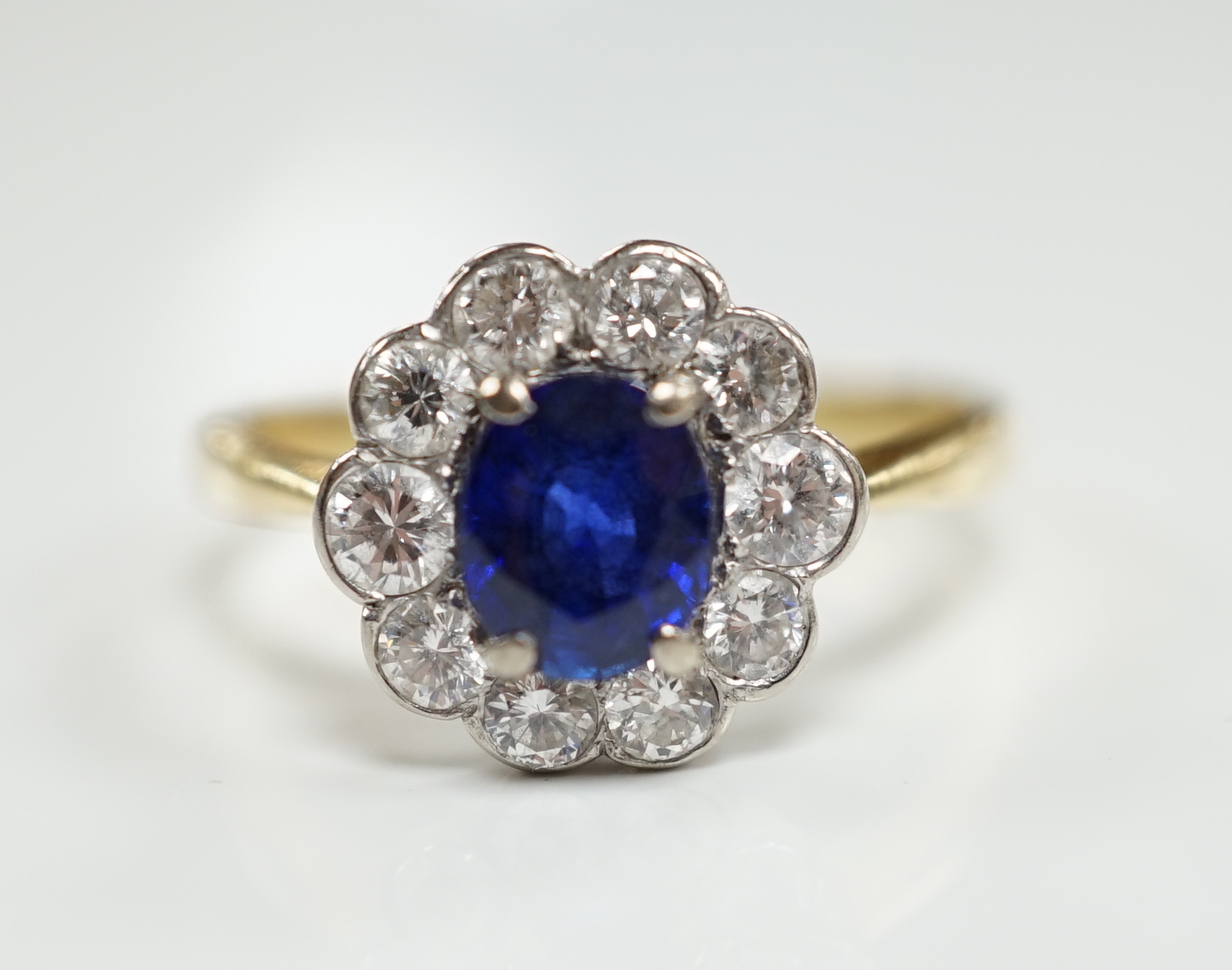 A modern 18ct gold, sapphire and diamond set circular cluster ring, size P/Q, gross weight 3.8 grams.